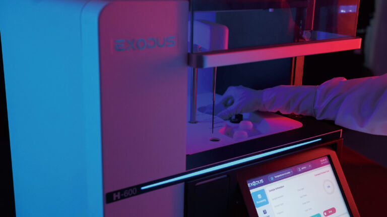 Step 1 EXODUS H-600 — carregamento de amostra para isolamento automático de exossomos Operador carregando amostra biológica no reservatório do EXODUS H-600 (Step 1), com interface touchscreen ao fundo exibindo informações do processo.